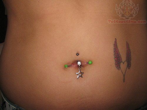 Belly Piercing With Star Stud And Winged Heart Tattoo